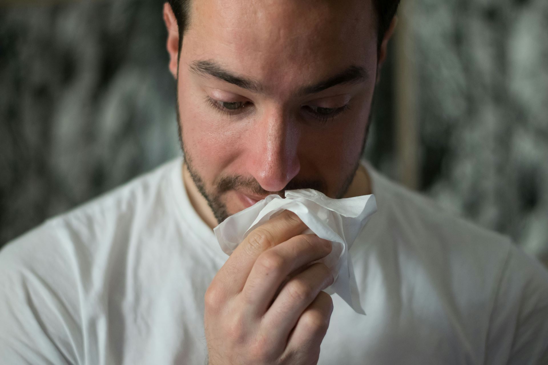 man with tissue to his mouth